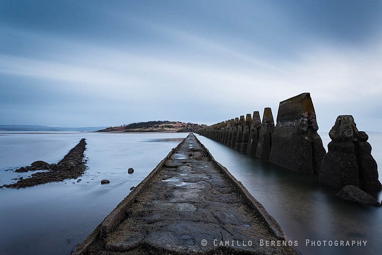 The causeway to Cramond island near Edinburgh as the tide rolls in on a cloudy morning.