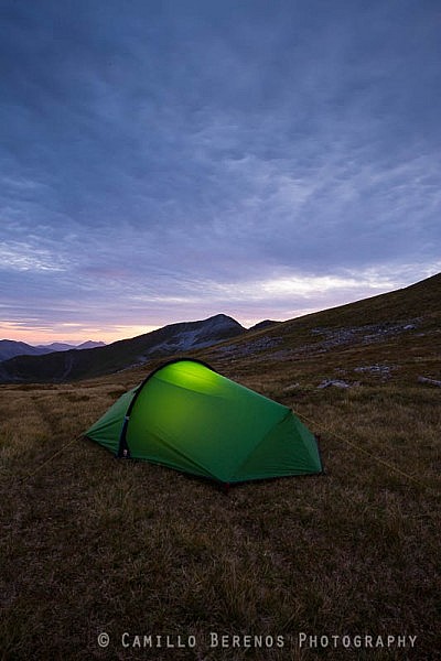 Torch lit tent high up in the Mamores while wild camping in Scotland