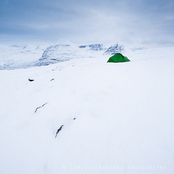 A tent pitched in the snow of the Torridon hills while wild camping in winter