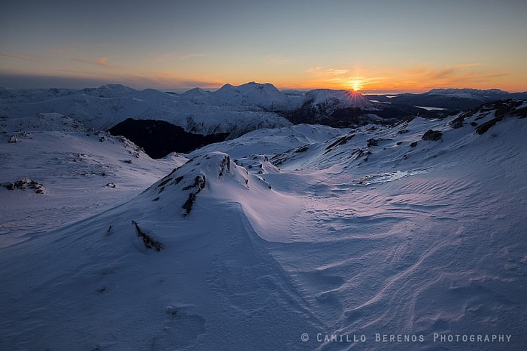 The sun setting behind the Arnisdale hills, with the Black Cuillin on the Isle of Skye on the far right