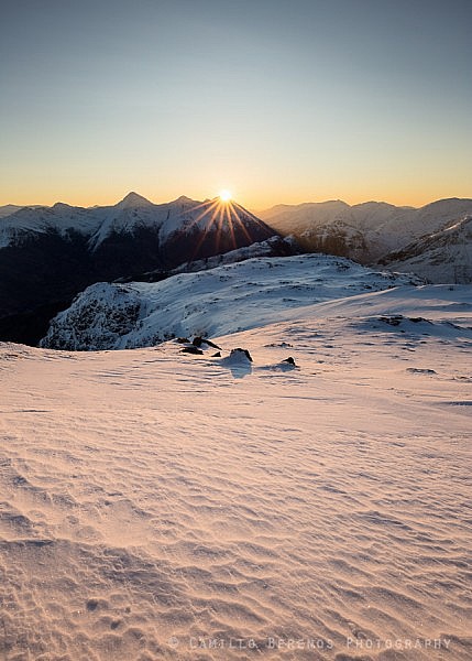 After a long cold night the sun finally rises above the Kintail ridge while illuminating the textured snowy foreground