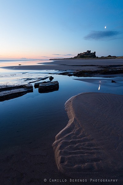 Moon over Bamburgh castle at dawn