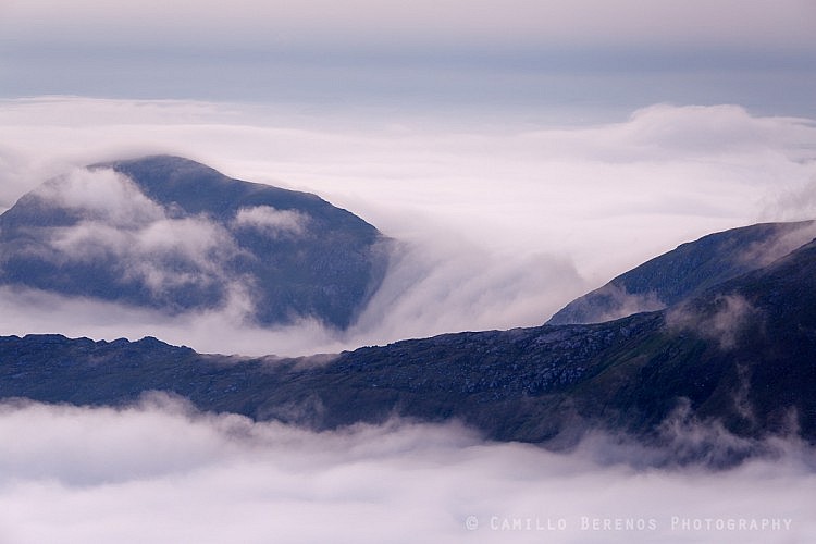 An inversion rolling over a saddle in between two hills at dawn